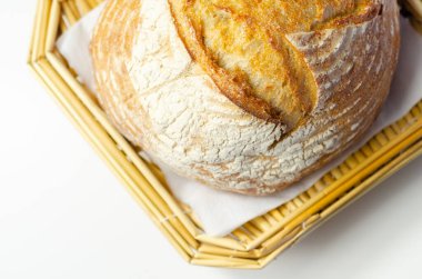 Geleneksel yuvarlak ekmek somunu klasik bir tarifle pişirilir, hasır sepette servis edilir, fırında.