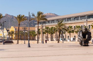 CARTAGENA, SPAIN - 22 FEBRUARY 2019 Statue bronze represents the figure of a seated man, naked and helpless, hugging his legs and with his head down, in an almost fetal position