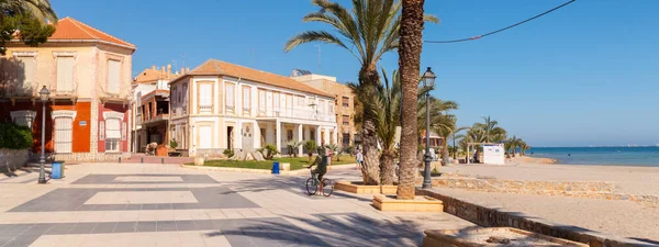 LOS ALCAZARES, SPAIN - 25 Şubat 2019 Los Alcazares şehri 50 yılı aşkın süredir popüler bir aktör tarafından seçilen bir tatil beldesiydi, ölümünden sonra kendisine ithaf edilen bir heykel, onu tipik bir resimde, bisiklette ve şapkada tasvir eder.