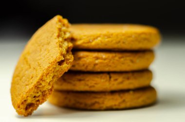 Beyaz arka planda bir yığın tarçınlı yulaflı kurabiyeye yaklaş, lezzetli ve sağlıklı bir atıştırmalık.