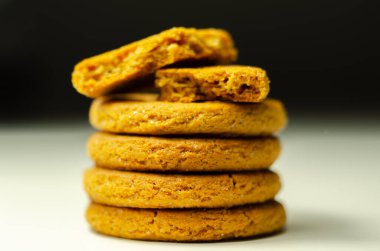 Beyaz arka planda bir yığın tarçınlı yulaflı kurabiyeye yaklaş, lezzetli ve sağlıklı bir atıştırmalık.