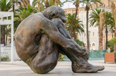 CARTAGENA, SPAIN - 12 SEPTEMBER 2022 Bronz heykel, çıplak ve yardıma muhtaç bir adam figürünü temsil ediyor.