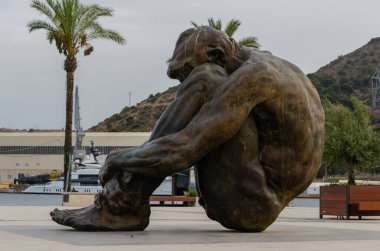 CARTAGENA, SPAIN - 12 SEPTEMBER 2022 Bronz heykel, çıplak ve yardıma muhtaç bir adam figürünü temsil ediyor.