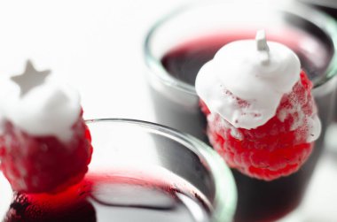 Ahududu ve kremadan yapılmış Noel ağacı süslemeli kırmızı bir içecek. Tatlı bir likör.