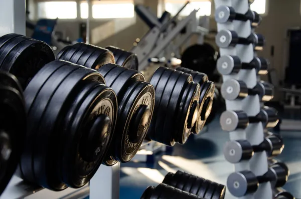 Dambıl, salonda dambıl. Fitness için spor salonu. Spor salonunda egzersiz aletleri..
