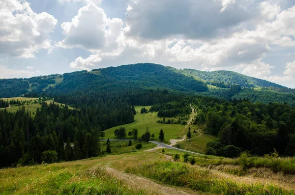 Hiking trail in the mountains highlands. Beautiful views of the mountains in the summer. Green trees and beautiful cloudy sky.