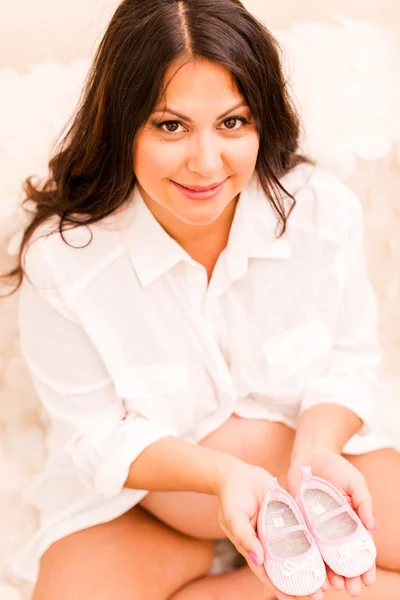 Pregnant woman with baby slippers — Stock Photo, Image