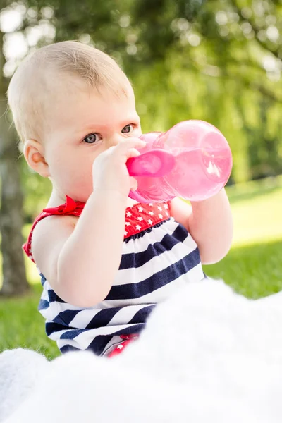 Schattige babymeisje met haar fles — Stockfoto