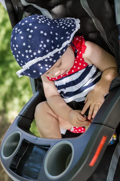 Meisje van de baby in haar wandelwagen. — Stockfoto