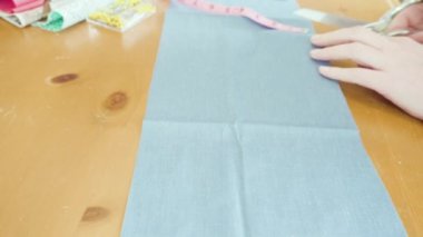 Koronavirüs salgını için dikiş makinesiyle pamuk yüz maskesi dikiyorum..