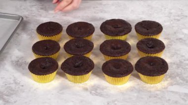 Tek boynuzlu at temalı doğum günü partisi için mavi tereyağlı krema ve gökkuşağıyla süslenmiş çikolatalı kekler..