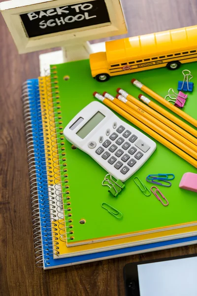 Schoolbenodigdheden, potloden, speelgoed schoolbus, Opmerking boek, rekenmachine — Stockfoto