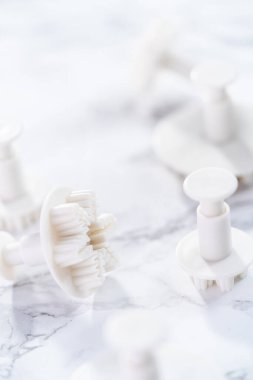Mermer bir yüzey üzerinde kar tanesi şeklindeki kurabiye kesicilerin yakın görüntüsü.