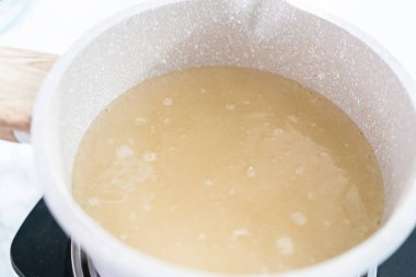 Ev yapımı lolipop yapmak için tencerede karamelize şeker.