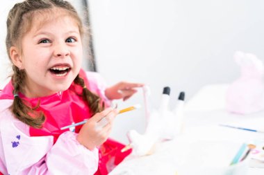 Küçük kız COVID-19 salgınında evde uzaktan öğrenim için sanat projesi üzerinde çalışıyor..