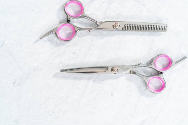 Gri arkaplanda yeni berber pembe makas.