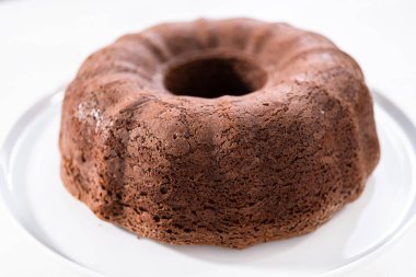 Beyaz pasta standında taze pişmiş çikolatalı kek..