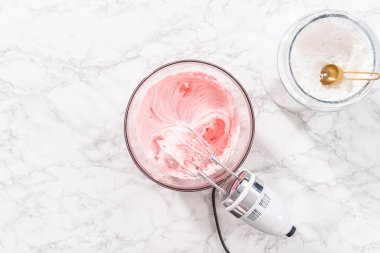 Düz yatıyordu. Marketten alınmış tereyağlı kremanın karışımı bardakta karıştırılıyor..