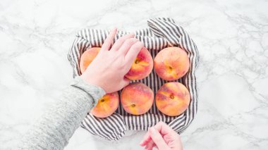 Düz yatıyordu. Adım adım. Mermer arka planda sepetteki organik şeftaliler..