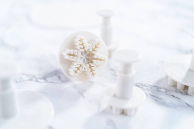 Mermer bir yüzey üzerinde kar tanesi şeklindeki kurabiye kesicilerin yakın görüntüsü.