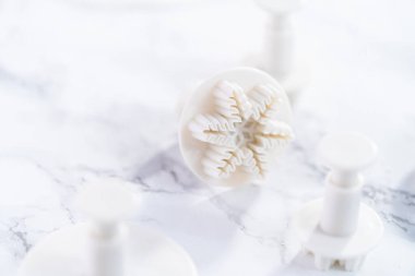 Mermer bir yüzey üzerinde kar tanesi şeklindeki kurabiye kesicilerin yakın görüntüsü.