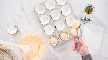 Düz yatıyordu. Adım adım. Vanilyalı Mardi Gras keki pişirmek için kek hamurunu folyoya batırıyorum..