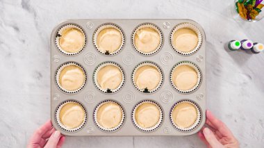 Düz yatıyordu. Adım adım. Vanilyalı Mardi Gras keki pişirmek için kek hamurunu folyoya batırıyorum..