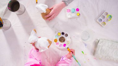 Düz yatıyordu. Evde resim dersinde kağıt heykel boyayan küçük bir kız..