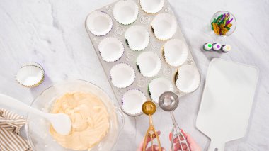 Düz yatıyordu. Adım adım. Vanilyalı Mardi Gras keki pişirmek için kek hamurunu folyoya batırıyorum..