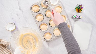 Düz yatıyordu. Adım adım. Vanilyalı Mardi Gras keki pişirmek için kek hamurunu folyoya batırıyorum..