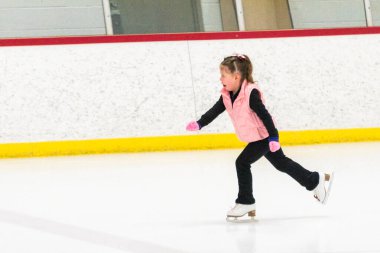 Küçük patenci sabah artistik patinaj antrenmanında elementlerini çalışıyor..
