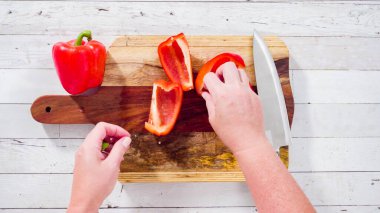 Düz yatıyordu. Ağaç kesme tahtasındaki organik kırmızı dolma biberler..