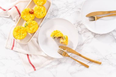 Düz yatıyordu. Beyaz tabakta dilimlenmiş pastırma ve peynirli kek..