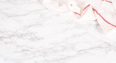 Beyaz ve kırmızı mutfak havlusu mermer mutfak tezgahında.