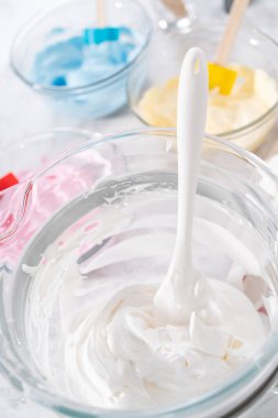 Tek boynuzlu at teması meringue popu hazırlamak için besin renklerine karıştırıyorum..