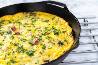 Fırınlanmış ıspanak ve jambonlu frittata dökme demir tavada..