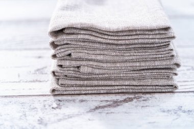 Ahşap beyaz bir masada doğal renkte keten bir peçetenin yakın görüntüsü..