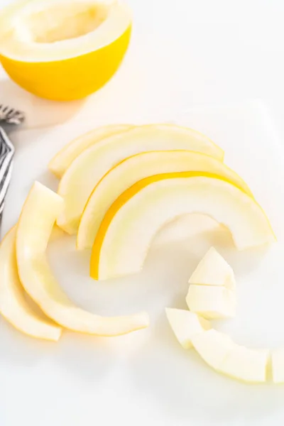 Slicong Melón Dewlicious Oro Una Tabla Cortar Blanca — Foto de Stock