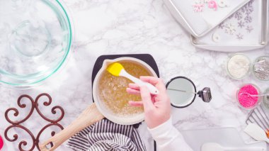 Düz yatıyordu. Adım adım. Küçük elektrikli ocağın üzerinde küçük bir tencerede karamelize şeker.