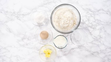 Düz yatıyordu. Adım adım. Mutfak masasında çörek pişirmek için gerekli malzemeler..