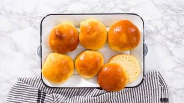 Düz yatıyordu. Adım adım. Taze pişmiş çörekler metal servis tepsisinde.