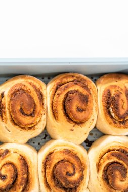 Mavi bir tavada taze pişmiş tarçınlı rulo..