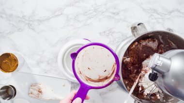 Düz yatıyordu. Adım adım. Ayakta duran bir mutfakta ev yapımı çikolatalı dondurma hazırlıyorum..