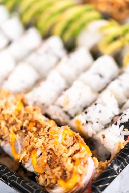 Önceden paketlenmiş suşi ve suşi çeşitleri plastik tepside..