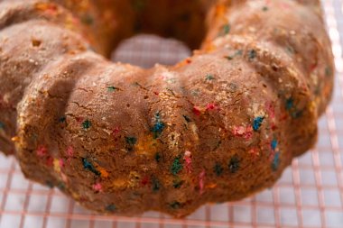 Manzarayı kapat. Taze pişmiş funfettti kekini tel askıda serinletiyor..