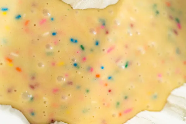 Cake batter in a bundt cake pan to bake funfettti bundt cake.