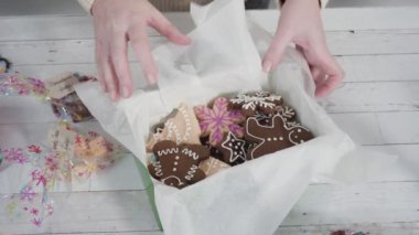 Hediyeler için ev yapımı zencefilli ekmek ve şeker Noel kurabiyeleri paketliyorum..