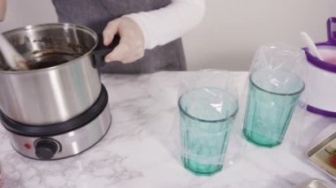 Çikolata kaplı çilekleri hazırlamak için cam bir kasede erimiş çikolata..