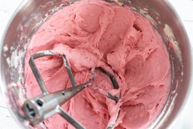 Çikolata ahududu kekleri için mutfak mikserinde ahududu kremalı peynir tereyağı hazırlıyorum..