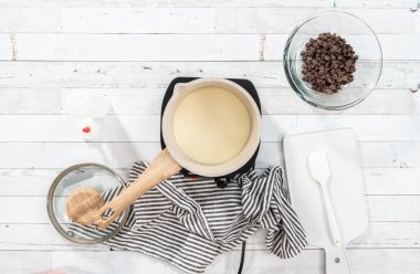 Düz yatıyordu. Çikolata ahududu kekleri için ev yapımı çikolatalı ganache hazırlıyorum..